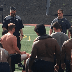 Coach addressing athletes on the field