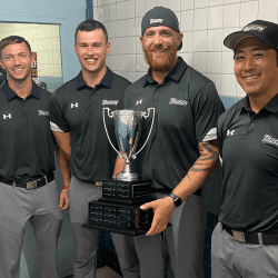 Strength and conditioning staff with a championship trophy